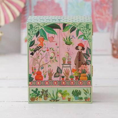 A Djeco Music Box Secret Garden with a picture of a woman in a garden.