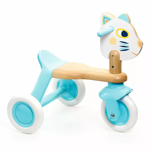 A Djeco BabyScooti Ride-on with a cat on top of it.