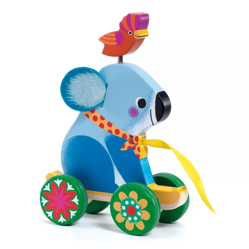 A blue Djeco Otto Pull along Toy with a bird on top of it.
