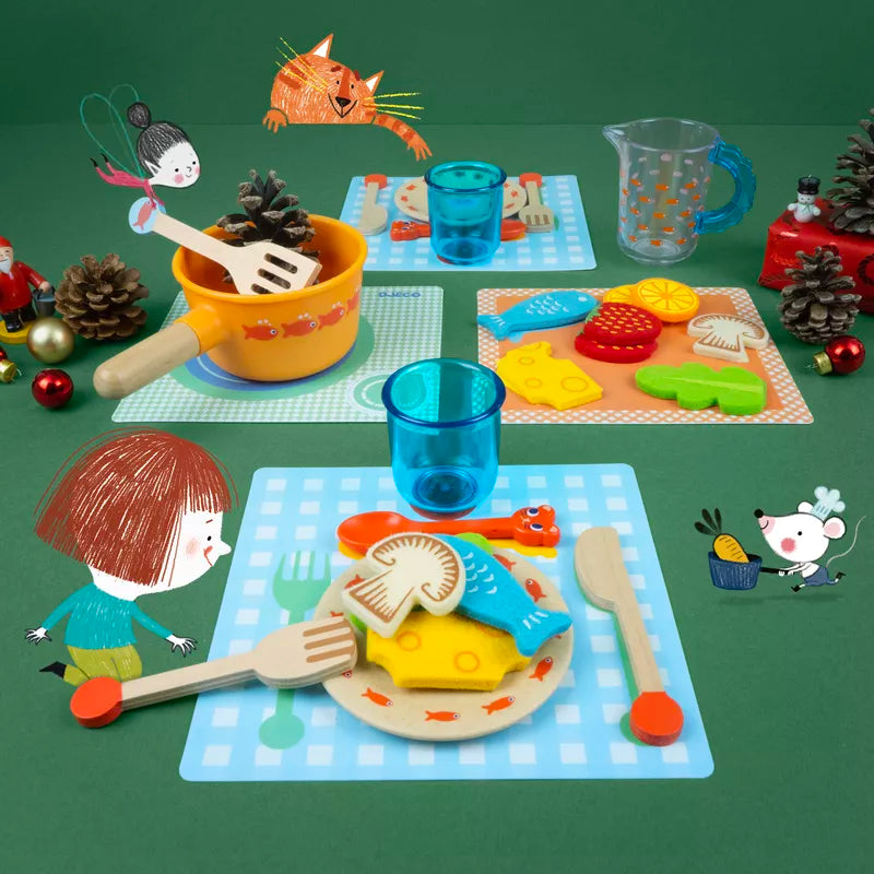 A Djeco Early Role Play Diner time, kittens! play kitchen set on a green table.
