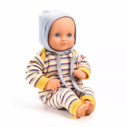 A Djeco Baby Canary Baby Doll sitting on a white surface.