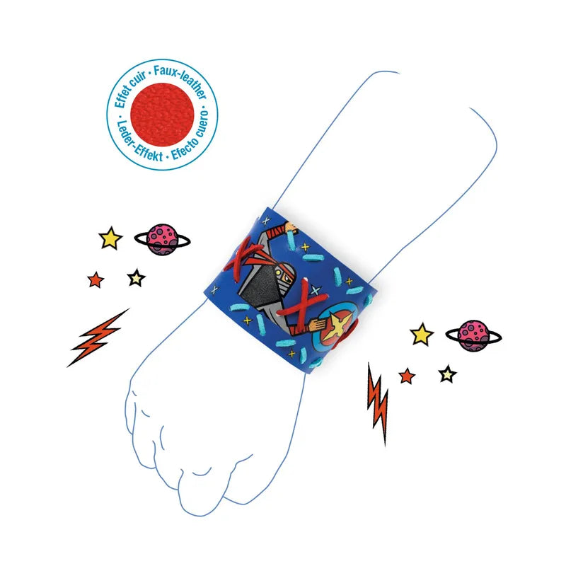 A white background showcases the Djeco Mosaics & Stickers Super-Powers - Fsc Mix, which includes a blue faux leather wristband adorned with a vibrant rocket and space motif. The wristband, echoing the style of superhero bracelets, is presented on an illustration of a forearm surrounded by drawings of stars, planets, and lightning bolts. A circular label states "Effet cuir - Faux-leather.