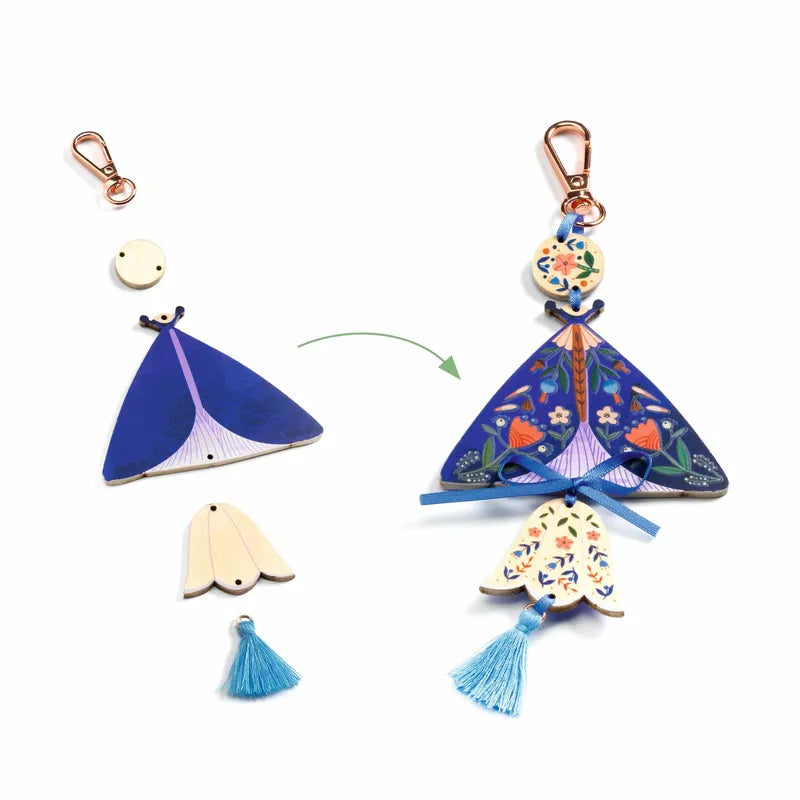 A Djeco Create Butterflies with wooden charms, a blue dress, and a blue tassel.