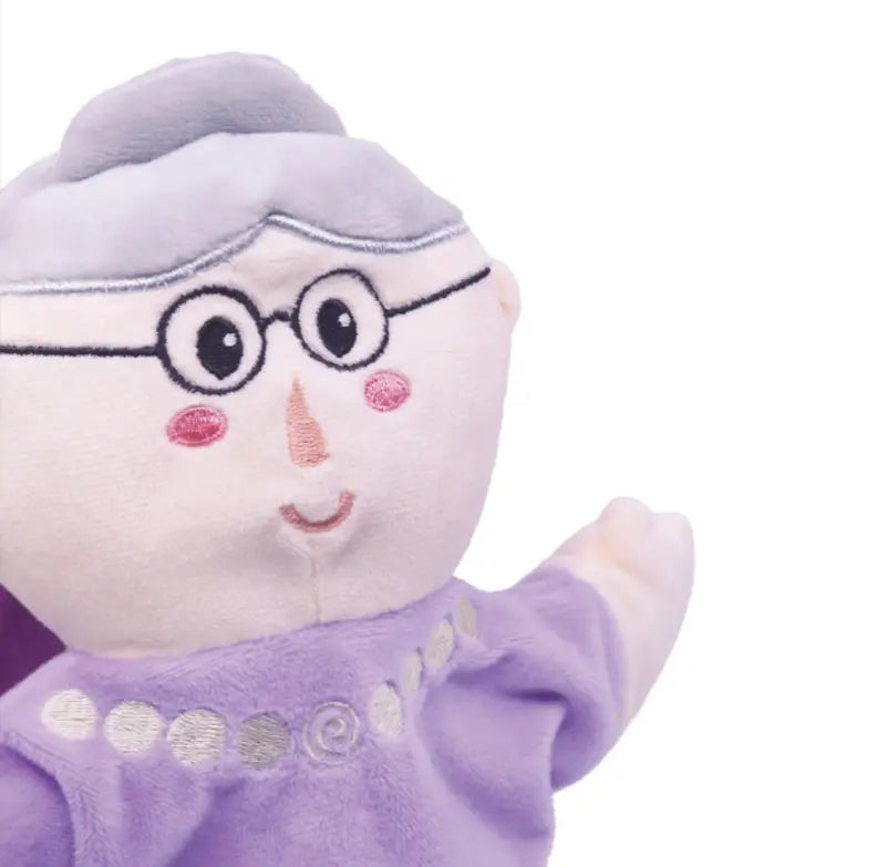 The Double-Face Hand Puppet Grandma-Fairy features an elderly woman with gray hair, glasses, rosy cheeks, and a lavender dress with a silver pattern—ideal for creative play. Shown against a white background.