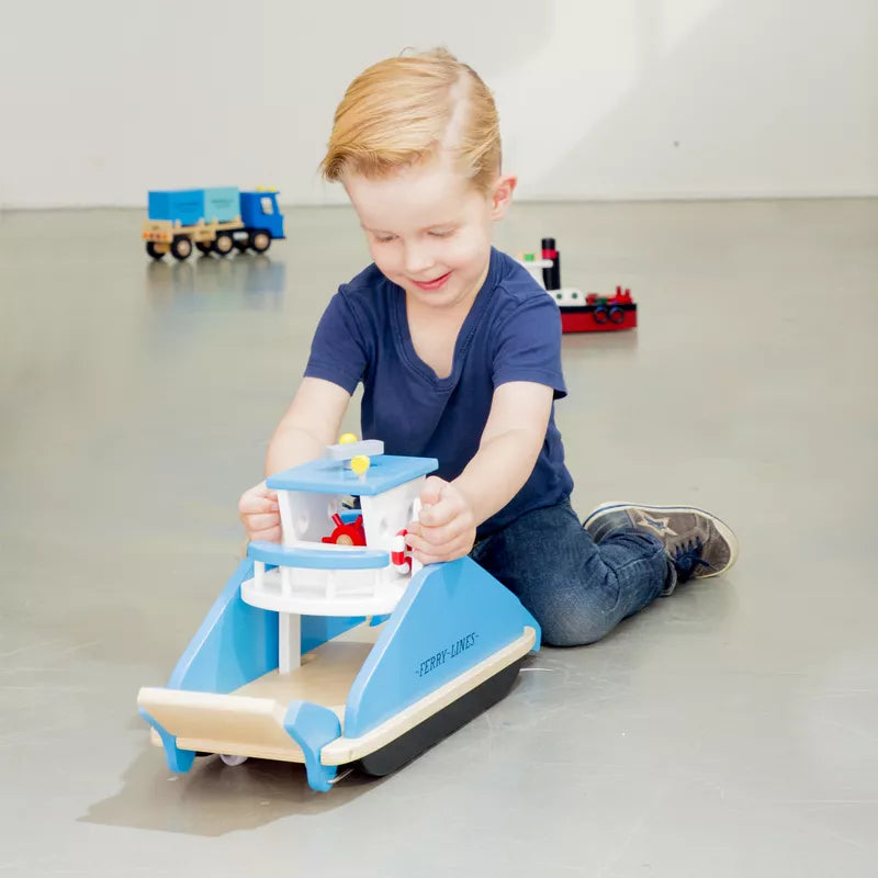 A young boy playing with a New Classic Toys Ferryboat Wooden Toy.