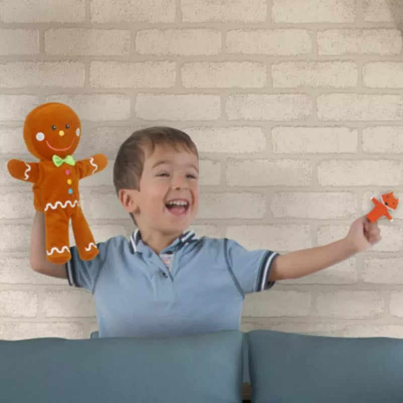 A boy holding a Fiesta Crafts Gingerbread Man with Finger Puppets Set stuffed animal.