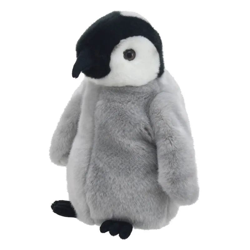 The Puppet Company Full-bodied Hand Puppet Penguin Chick features soft gray fur, a white face, and black beak and feet. Designed as a soft toy puppet, it helps encourage children's fine-motor skills. Sits upright against a white background.