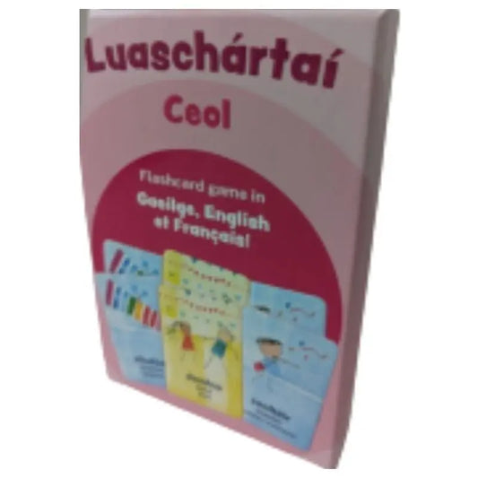 A pink box labeled "Luaschártaí - Ceol" displays music flashcards with colorful musical instrument illustrations. The trilingual set includes Gaeilge, English, and French text.