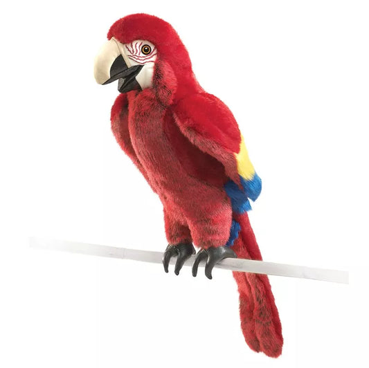 A Folkmanis Puppets Scarlet Macaw sitting on top of a white pole.