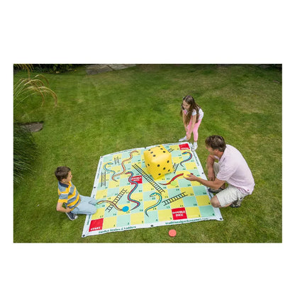 A family playing Garden Snakes & Ladders 2m in the grass.