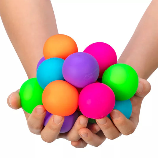 Two hands holding a cluster of Gobs of Globs Needoh fidget toy balls, including orange, purple, green, and pink, isolated on a white background.