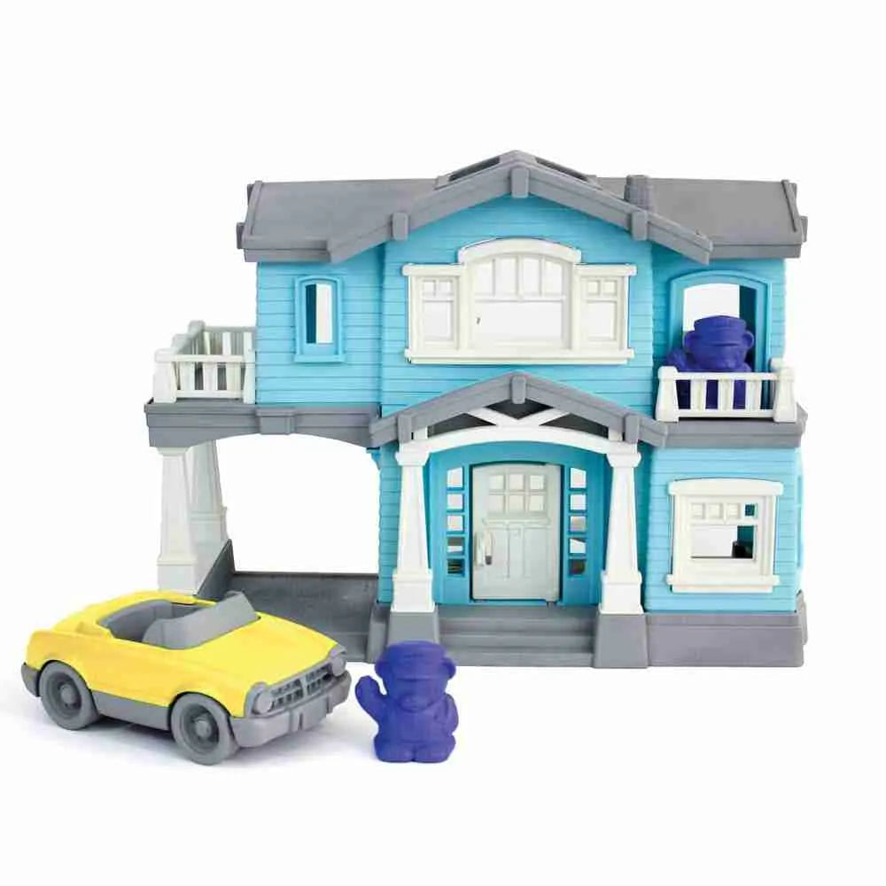 A GreenToys House Playset parked in front of a blue house.
