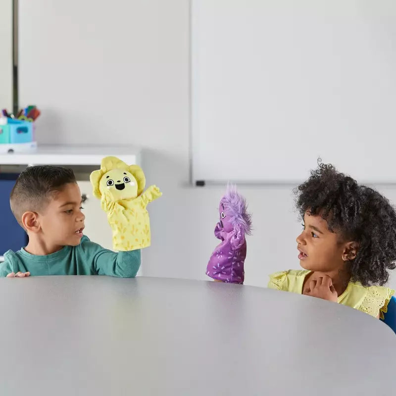 Two children engaging in sensory play with Learning Resources Feelings Family™ Hand Puppets at a table.