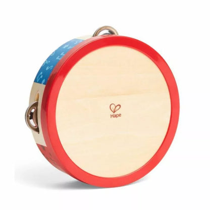 A red and blue Hape Tap-along Tambourine with a heart on it.