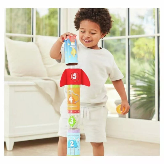 A young boy is playing with a Hape Rocket Ball Air Stacker.