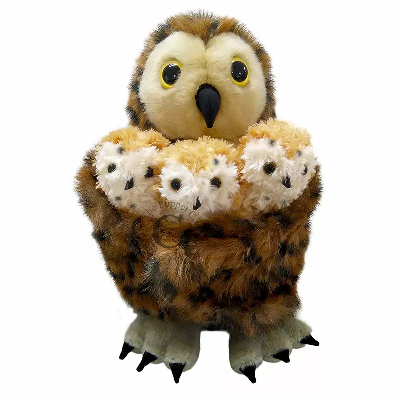 A The Puppet Company Hide-Away Tawny Owl holding a bunch of stuffed animals.