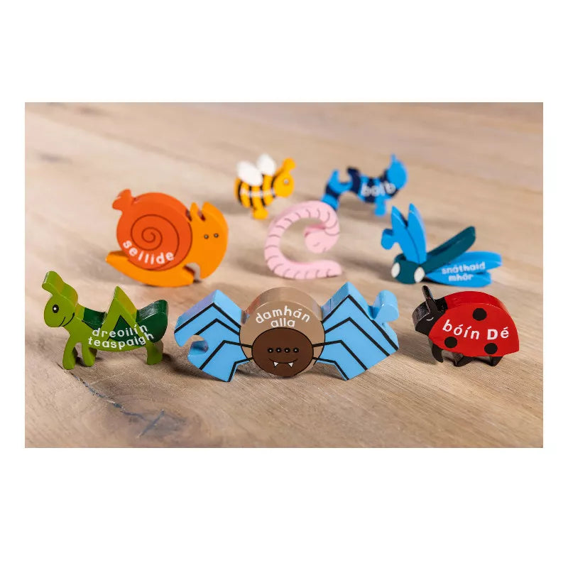 A group of Alphabet Jigsaws Creepy Crawlies in Irish Wooden Jigsaw magnets sitting on top of a wooden table.