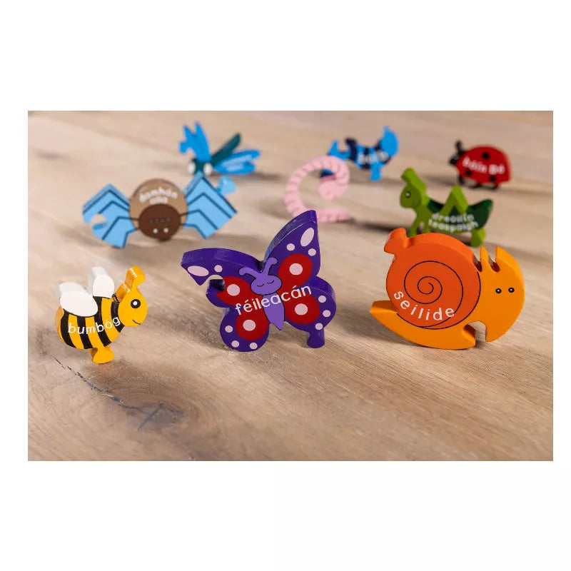 A group of Alphabet Jigsaws Creepy Crawlies in Irish Wooden Jigsaws sitting on top of a wooden table.