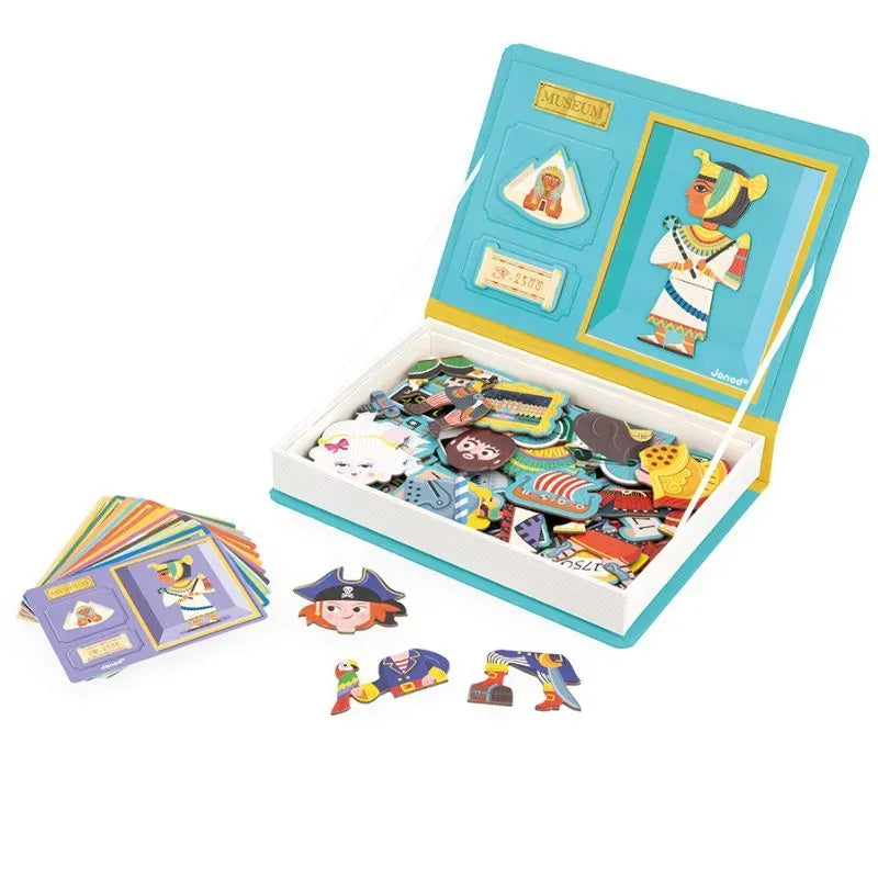 The Janod History Magneti'book is an educational puzzle set with magnetic pieces showcasing historical and cultural figures. The open box reveals colorful magnets and cards, with a completed Egyptian pharaoh magnet on the lid, surrounded by pieces for creating historical scenes.