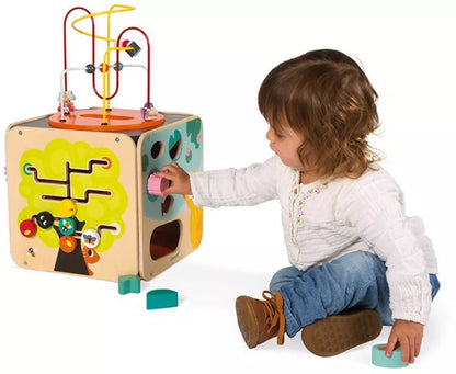 A little girl playing with a Janod Multi-Activity Looping Toy.