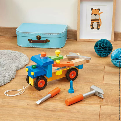 A Janod Brico’Kids DIY Truck with construction tools on the floor.