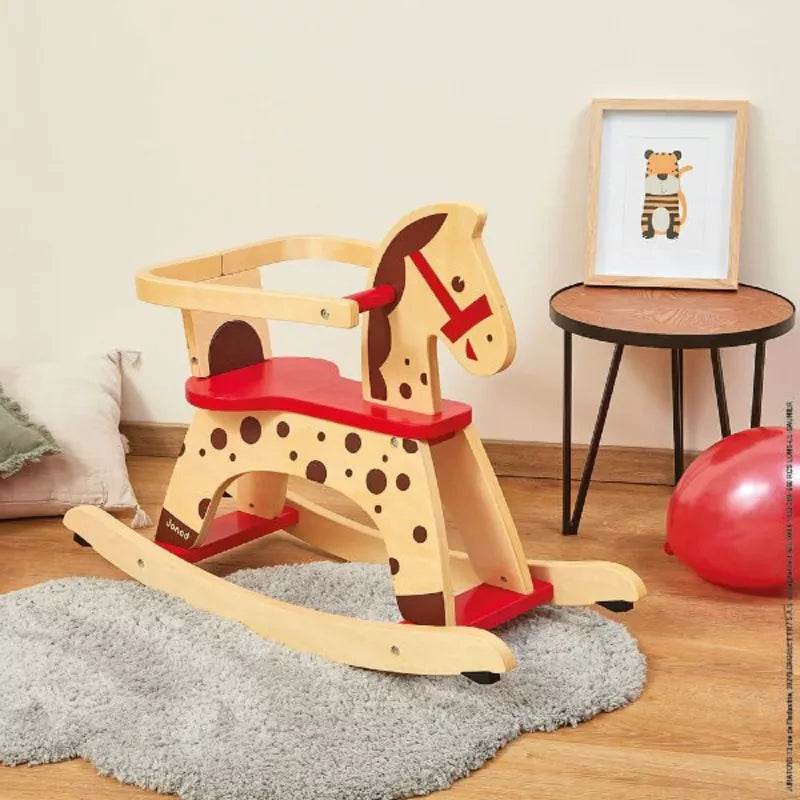 Janod Caramel Rocking Horse sitting on top of a wooden floor.