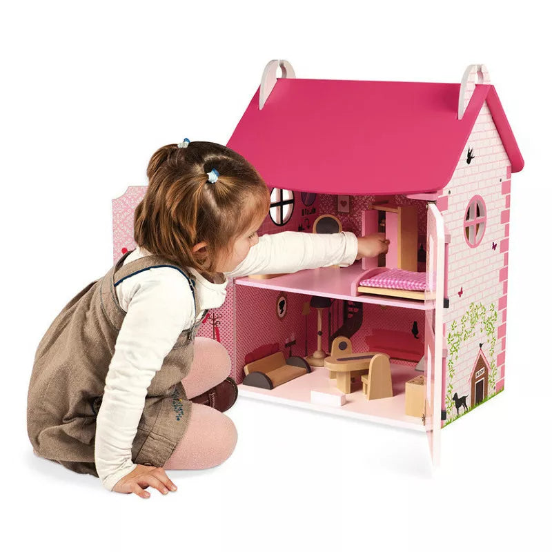 A little girl playing with a Janod Mademoiselle Doll's House.