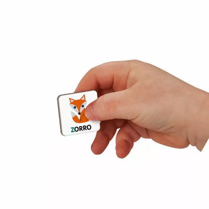 A person holding a small Janod Spanish Alphabet Magneti'book with a toy fox on it.