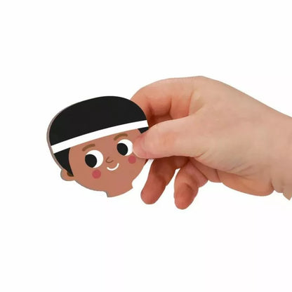 A child's hand is holding a Janod Magnetibook - Sports magnet.