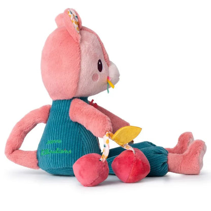 The Lilliputiens I'm Discovering Jeanne Multi-Activity Cat is an adorable plush toy, ideal as a baby gift. Featuring a pink head and limbs, it wears a blue-green outfit, holds a yellow cheese slice and red cherries. Embroidered face and patterned ears make it perfect for baby's first toy.