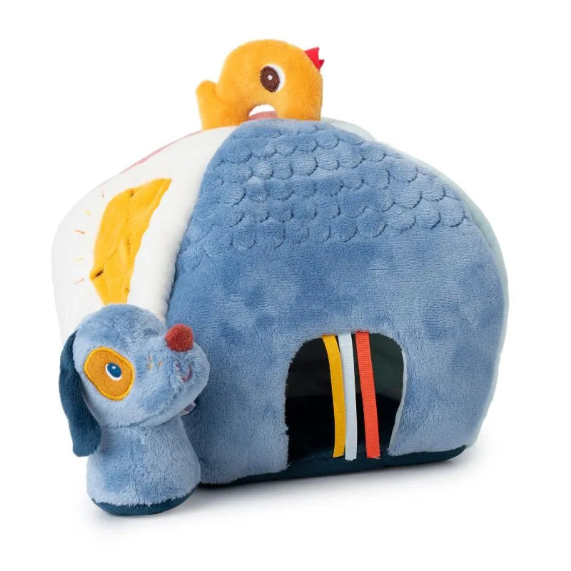 The Lilliputiens I'm Discovering Jules' House And 4 Hidden Rattles is a charming plush toy, perfect as a baby gift. It features a blue barn with a dog head at the entrance, an orange duck on top, and colorful ribbons adorning it—ideal for baby's first toy.