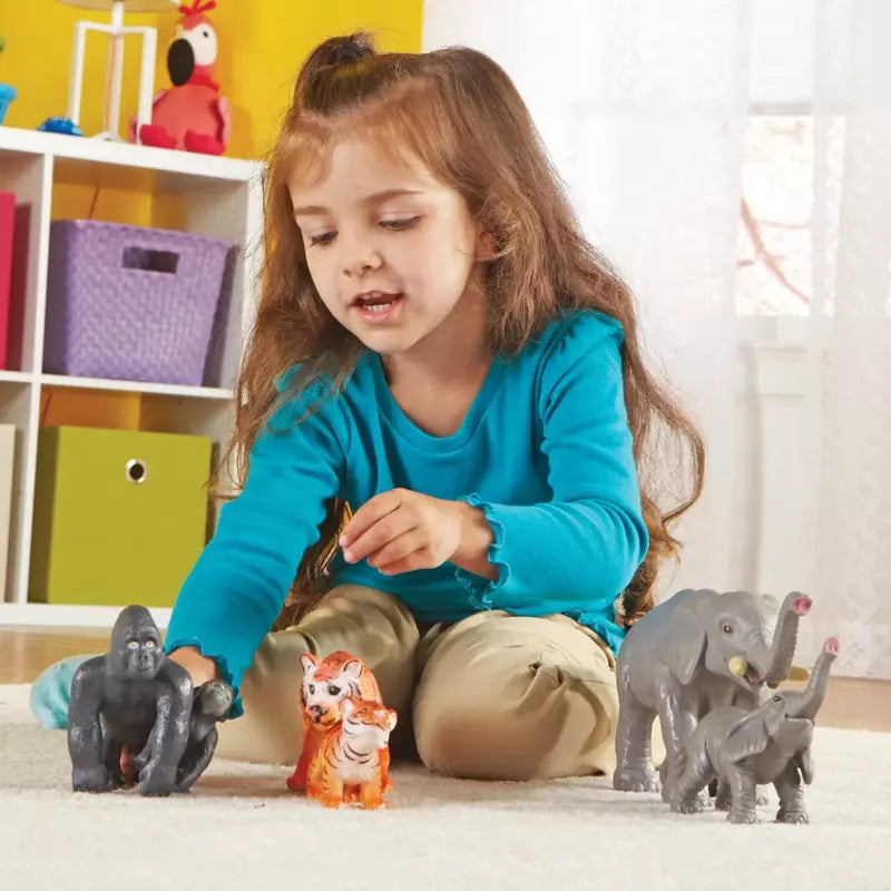 A durable set of Learning Resources Jumbo Jungle Animals - Mommas And Babies spark the imagination of a toddler as she plays on the floor.