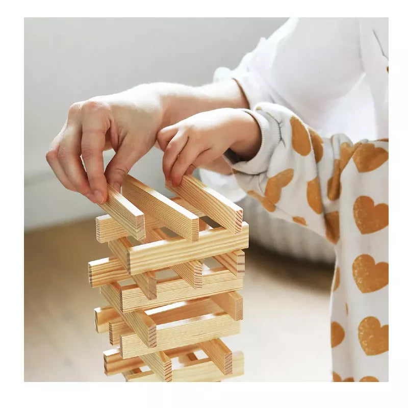 A child playing with a KAPLA® Construction 200 Planks tower.