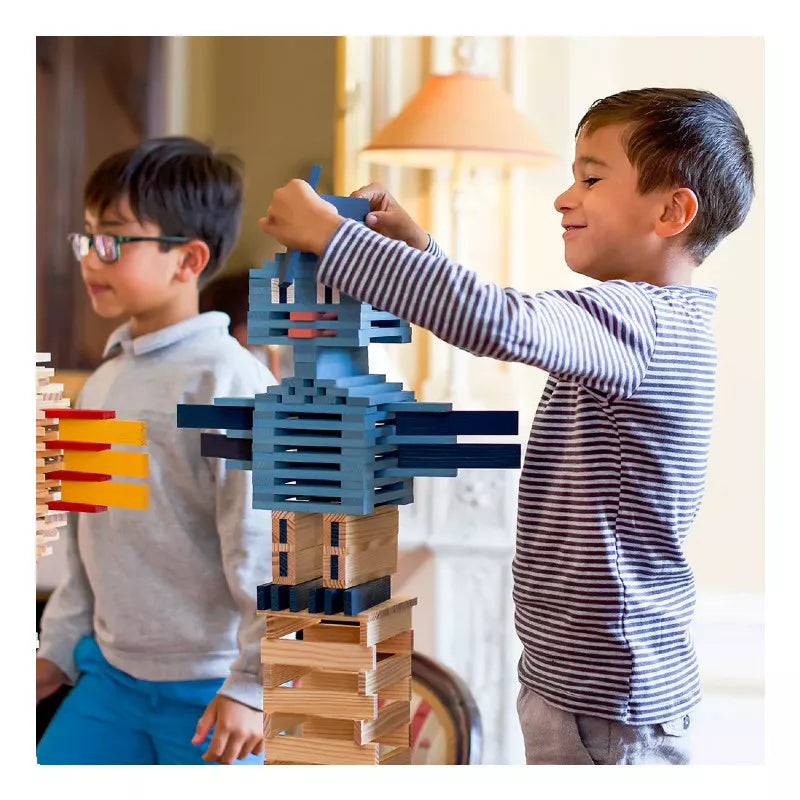 Two young boys playing with a KAPLA® 40 Coloured Planks Light Blue tower model.