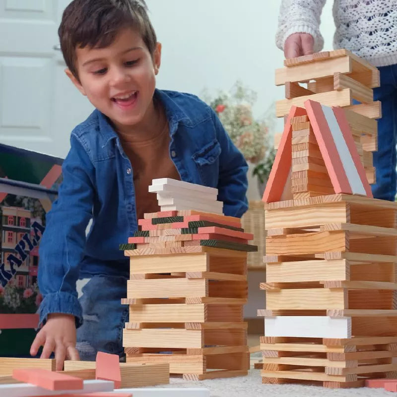 Two children are having fun building structures with KAPLA® 200 Spring Box wooden blocks - a popular construction toy.