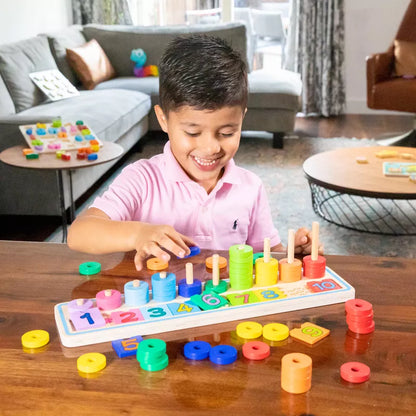 A young boy playing with New Classic Toys Learn to Count in a living room.