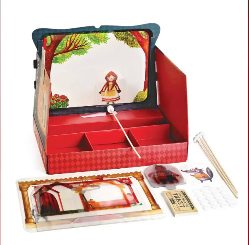 The Shadow Theatre – The Amazing Light Theatre of Wonders is an open storytelling playset with a stage, forest backdrop, Little Red Riding Hood and wolf shadow figurines, props, tickets, and stickers—all arranged on a white surface.