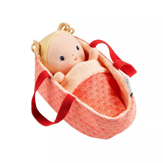 A Lilliputiens Baby Anais doll in a pink bag with a red ribbon.