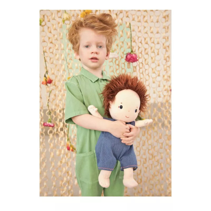A young boy holding a Lilliputiens Babydoll Charlie.
