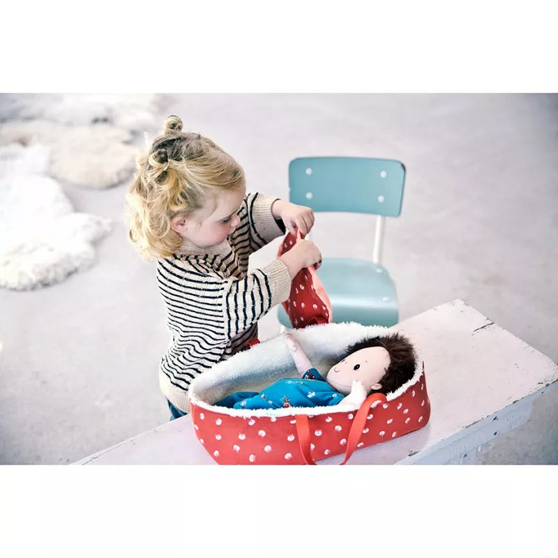 A little girl playing with a Lilliputiens Babydoll Basket.