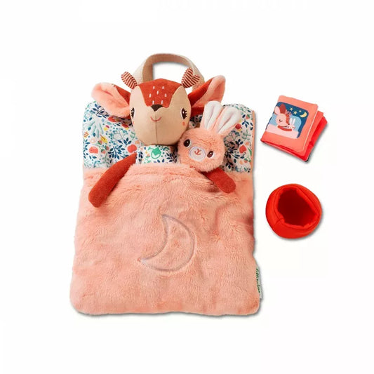 A cozy children's bedtime Lilliputiens Stella Bed Time Ritual with a cute deer character design, accompanied by a soft toy, a red feeding bowl, and a little red book.