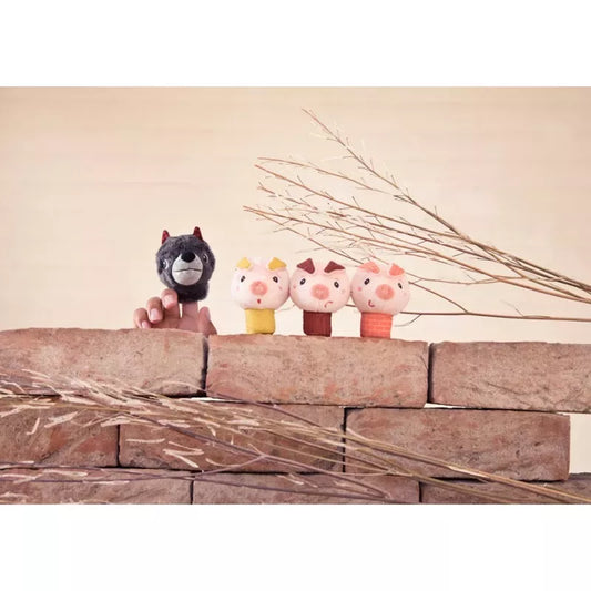 A playful lineup of ice cream treats designed to look like cute animals perched atop a brick wall, with delicate dried branches and Lilliputiens Louis The Wolf And The 3 Little Pigs Finger Puppets adding a touch of whimsy to the composition.