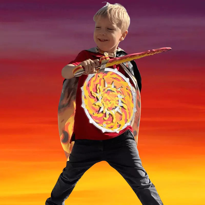 a young boy holding a Liontouch Flame Set Sword & Shield in front of a sunset.