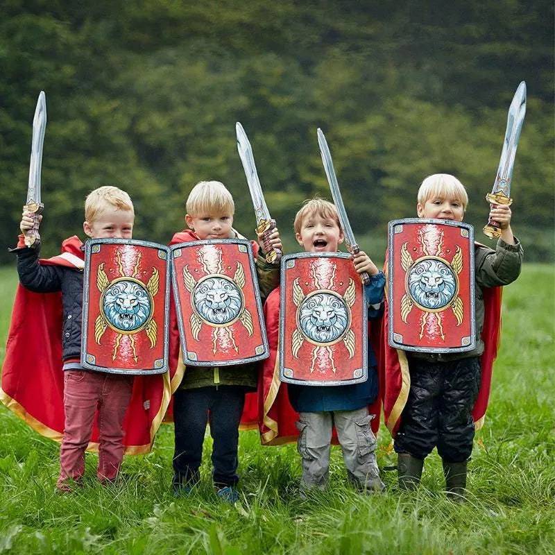 Four children dressed as romans holding shields in a field, wearing the Liontouch Roman Cape.