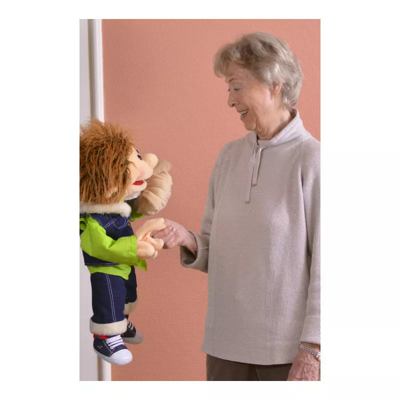 A woman holding Living Puppets Gerrit 65cm Hand Puppet next to a stuffed lion.