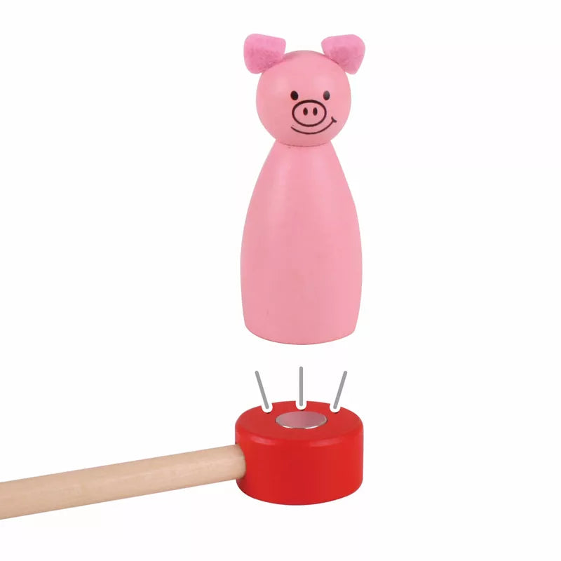 A pink Bigjigs Magnetic Theatre with a wooden stick sticking out of it.