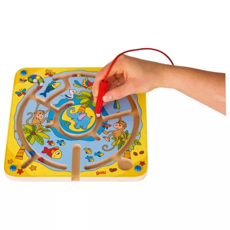 A child's hand is drawing on the Magnetic Maze Board Island.