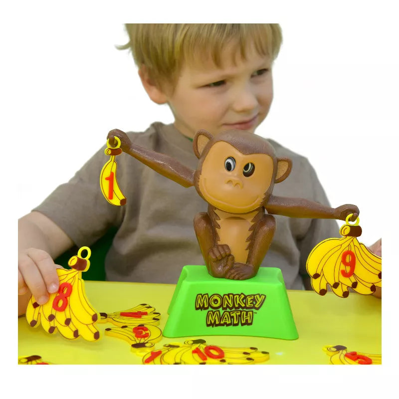 A young boy playing with a Monkey Maths Addition & Subtraction Game toy.