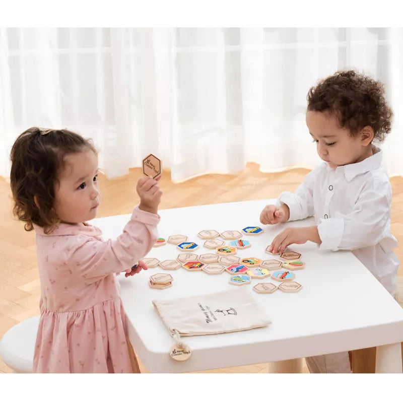 Two young children playing with New Classic Toys Memory Game - Vehicles on a table.