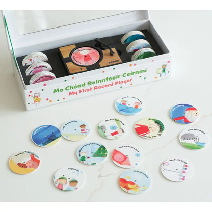 The Mini Gramophone Box Set includes a mini record player and colorful circular discs with illustrations and text, featuring several discs inspired by traditional Irish songs laid out in front of the box.